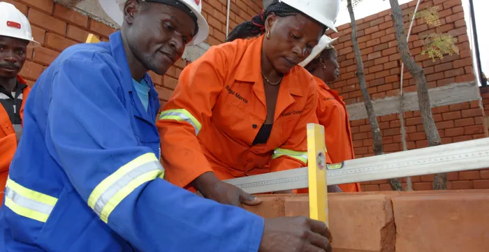 Man and woman building a house made of bricks 