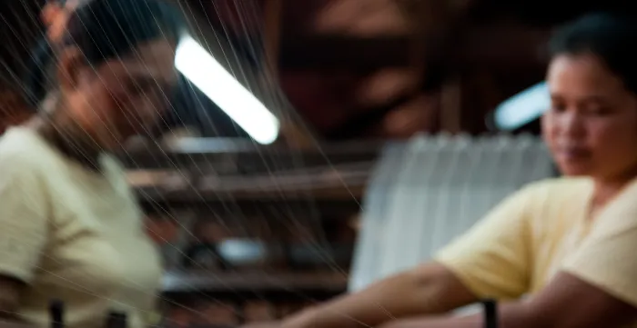 two women workers operating a weaving machine