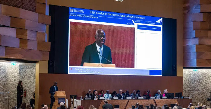 Large video screen feature the ILO Director Genral addressing the assembly