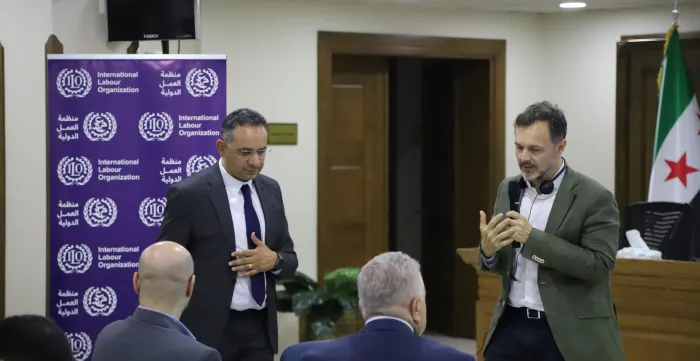 2 men speaking in front of an audience