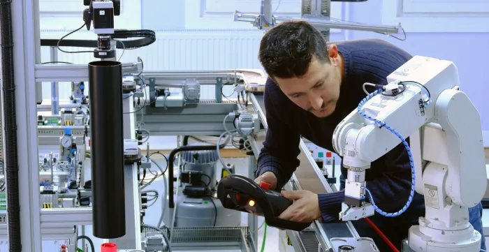 Man with a robot in a workplace