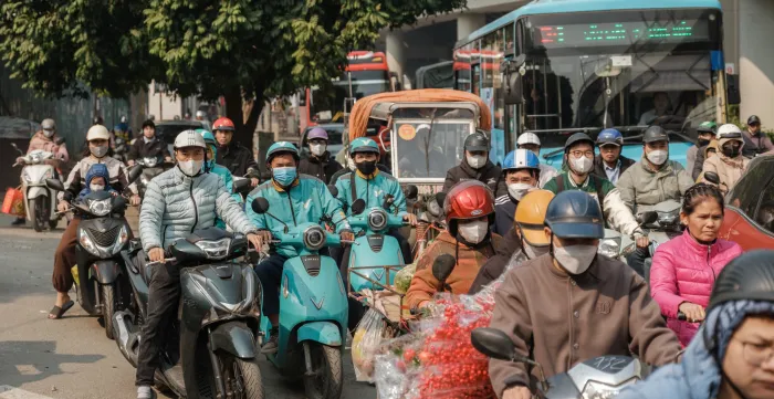 Chaotic traffic of motorbikes and cars travelling to work in Viet Nam