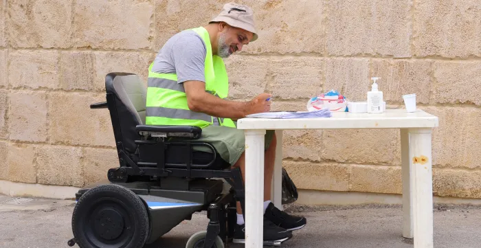 Raymond Khoury working while on his wheelchair