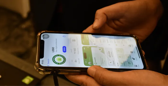 A Lao woman explores the functionalities of the new social security mobile app.