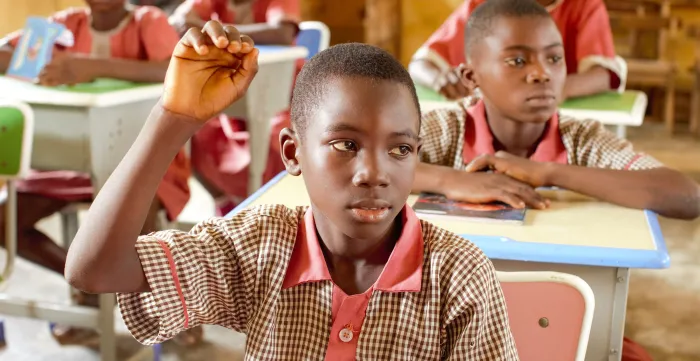 Alfa, a primary school pupil in Oke Agunla, Ondo State, Nigeria, raises his hand during a lesson after returning to school from child labour.