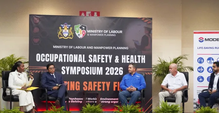 A panel of five professionals participates in a discussion on stage during the Occupational Safety & Health Symposium 2026, held by the Ministry of Labour and Manpower Planning.