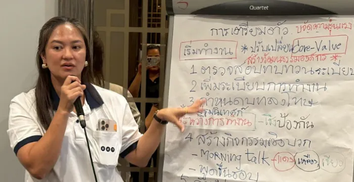 A workshop participant presents the results of a group discussion using a flipchart.