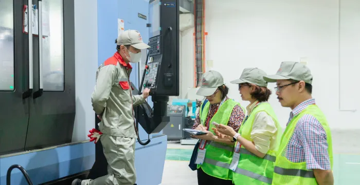 Consultants exchange on continuous improvement with workers during field activities of the Training of Trainers programme