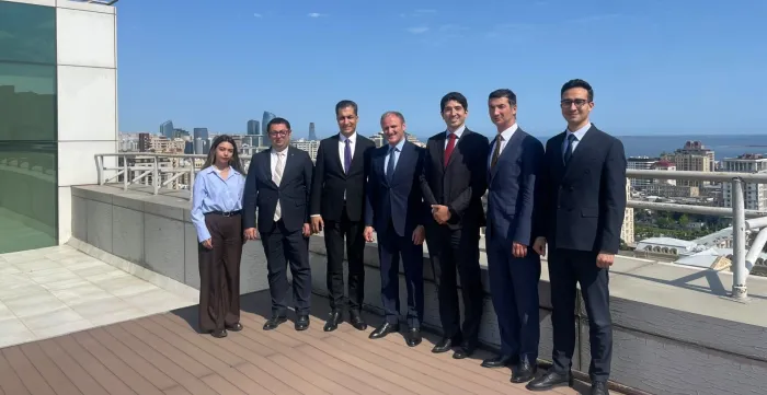 Seven people standing on a rooftop terrace