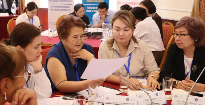 Group of people sitting around a table discussing a paper