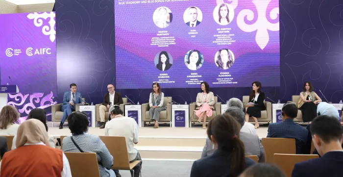 Six panellists seated on stage