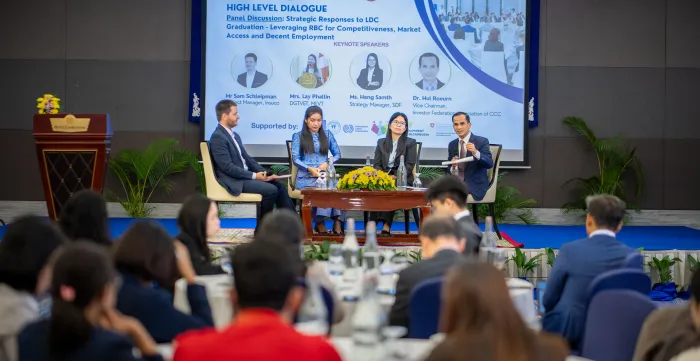our speakers participate in a panel discussion, as an audience listens.