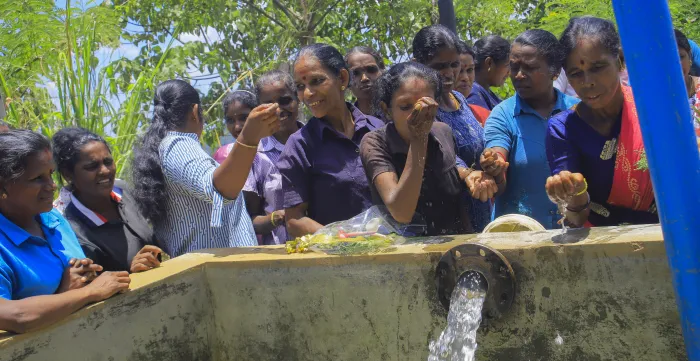 group of estate workers enjoying the new flow of clean water