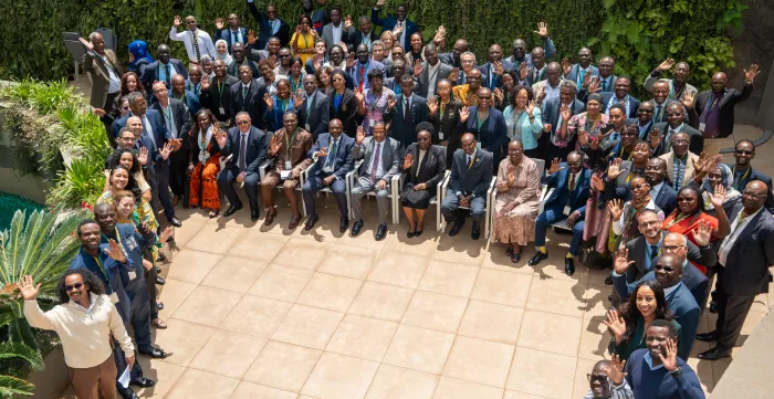 Large group of participants posing and waving during a regional meeting.