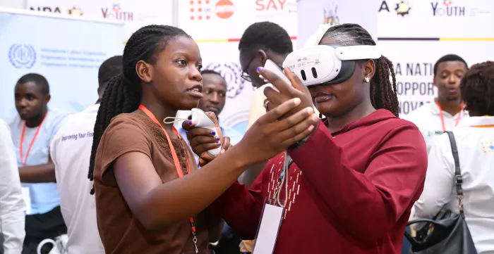 a trainer woman helping an event participant to operate virtual reality equipment