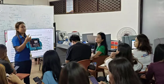 Lea Macababbad guides TESDA students during an AI classroom exercise.