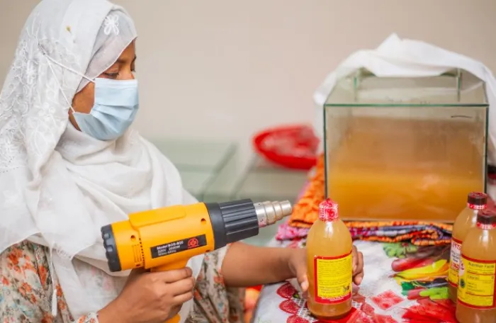 Reshma Akhter is preparing the bottles of apple cider vinegar for distribution