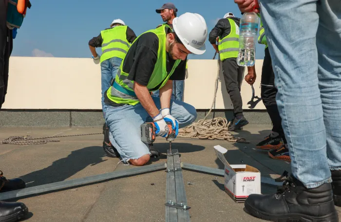 workers installing solar panels on a roof