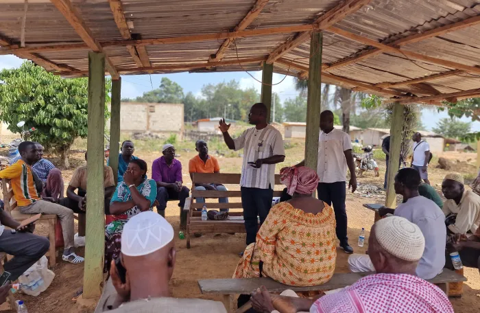 Group of villagers discussing under a shed