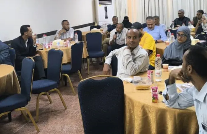 Business representatives sit in round tables listing to the presentations at the workshop.  