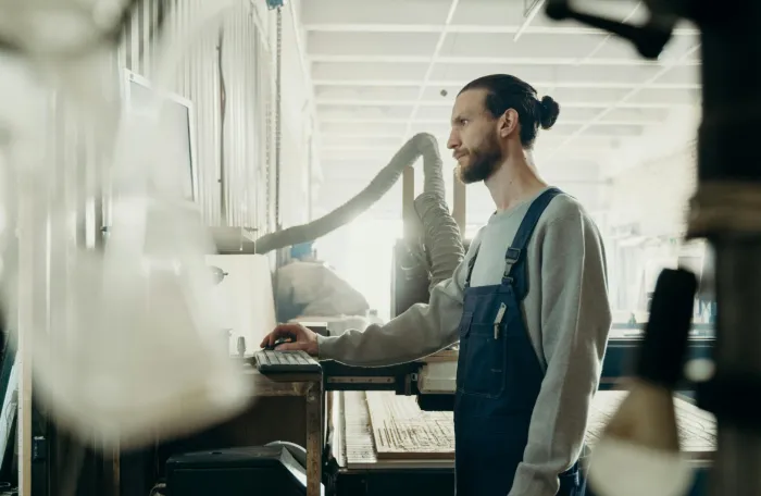 Factory worker standing in front of a computer