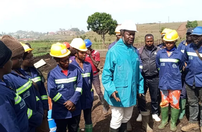Nkambe mayor speaks with road rehabilitation workers wearing safety gear.