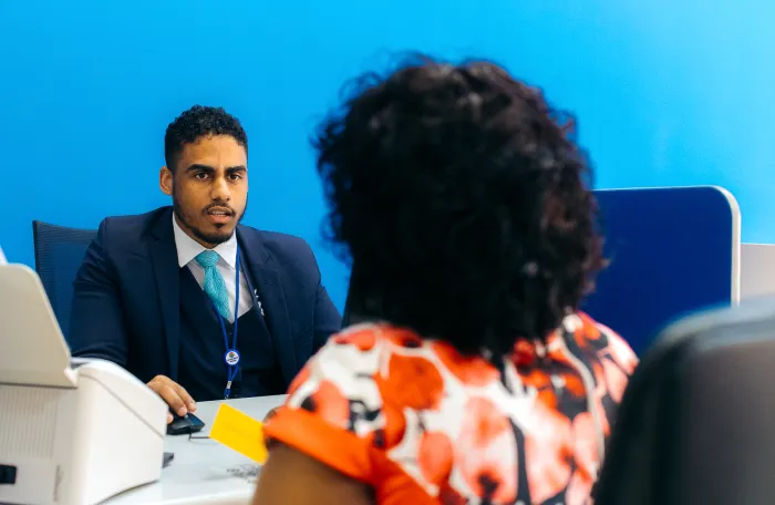 Homem de frente para uma mulher no balcão administrativo