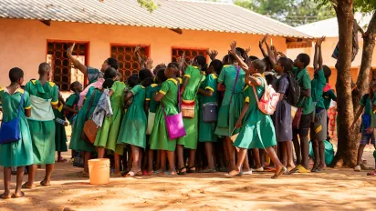 A lot of children in green uniform pose for a selfie in their schools