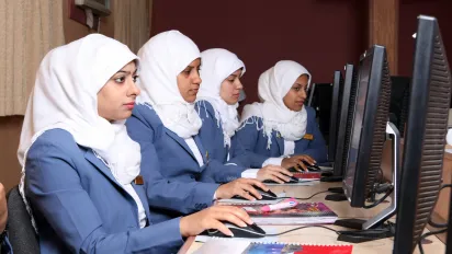 Women work on computers in a vocational training center.