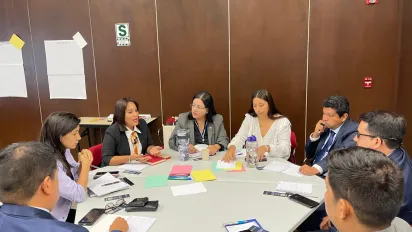 Personas sentadas en mesa redonda en trabajo de grupo