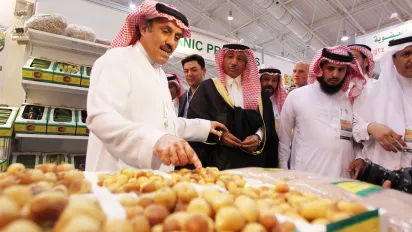 A local produce seller displays his dates to clients at an exhibition.