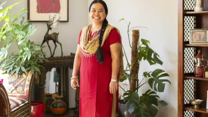 A Nepalese woman in traditional dress smiling in a house, in Qatar