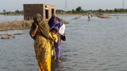 A family crosses the flooded streets of Pakistan.