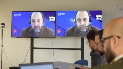 Fotografía de la sesión con Pablo Casalí, especialista de la OIT, en primer plano en pantalla conectado virtualmente dando introducción al espacio