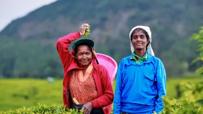 two women workers looking at the camera in a tea plantation