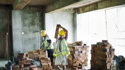 Myanmar construction worker carrying bricks