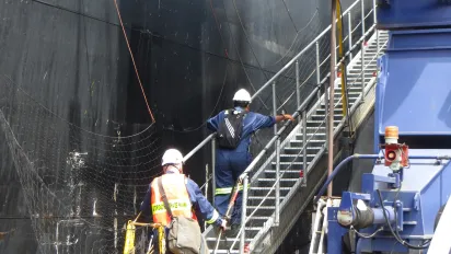 Two labour inspectors are boarding a container ship