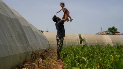 A man plays with his young daughter on a farm in Lebanon
