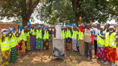 Women in Kapekaha village in northern Côte d'Ivoire stand proudly in a line, waving their hands after the completion of an ILO training course