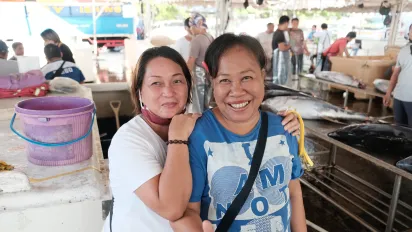 two women smiling at the camera in the fishing port of General Santos in the Philippines