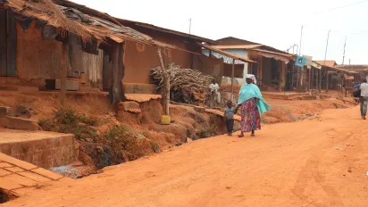 A lady walking with a kid on the roads of rural Cote d'Ivoire