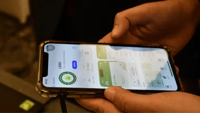 A Lao woman explores the functionalities of the new social security mobile app.