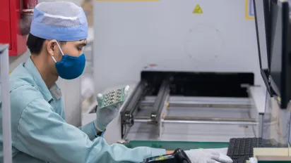 Worker inspecting a circuit board