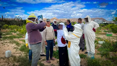 a group of people having a beekeeping training