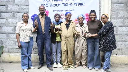 young men and women standing outside their cooperative poultry farm