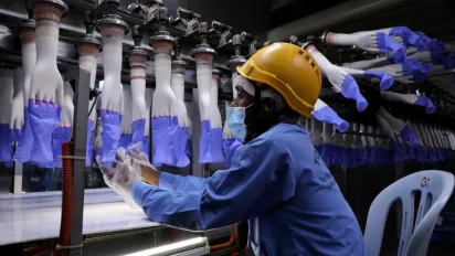 A worker overseeing production at a Malaysian rubber glove manufacturing facility