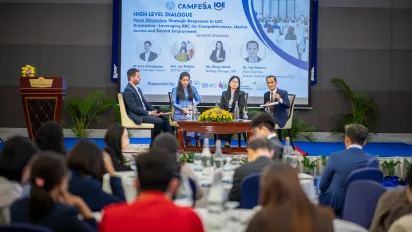 our speakers participate in a panel discussion, as an audience listens.