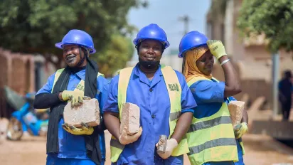Women workers wearing blue helmets and smiling