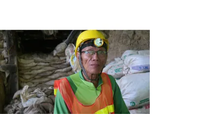 A worker in mining wearing a yellow hard hat.