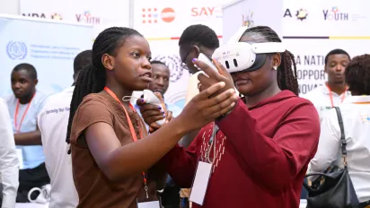 a trainer woman helping an event participant to operate virtual reality equipment